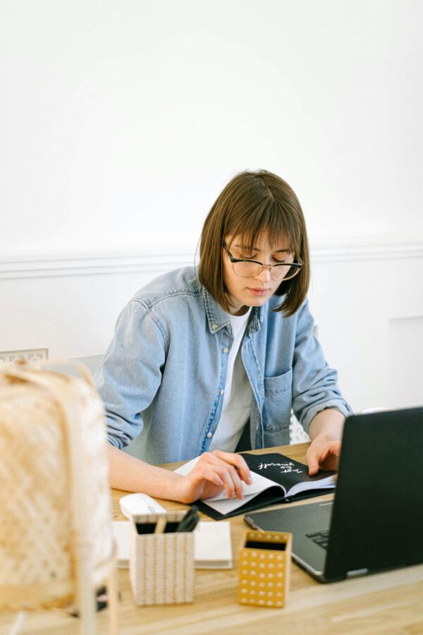 Young woman working on her laptop in a bright home office, focused and productive.
